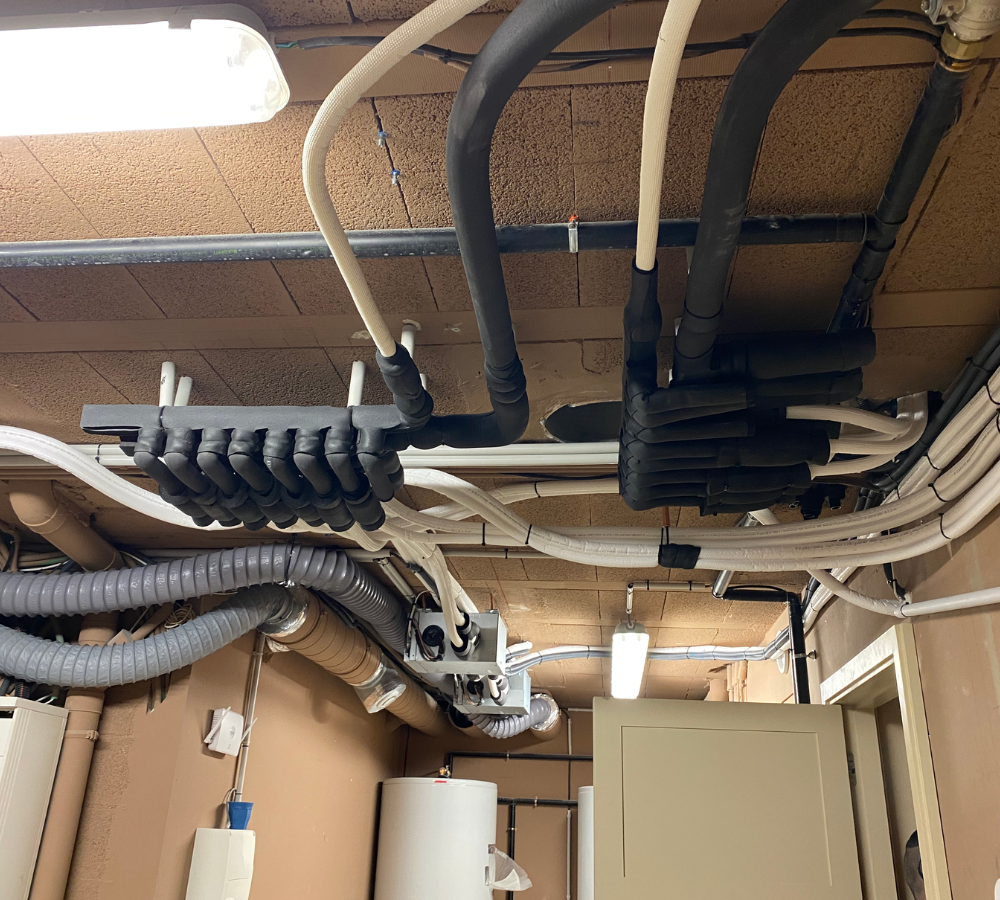 Une pièce avec beaucoup de tuyaux suspendus au plafond