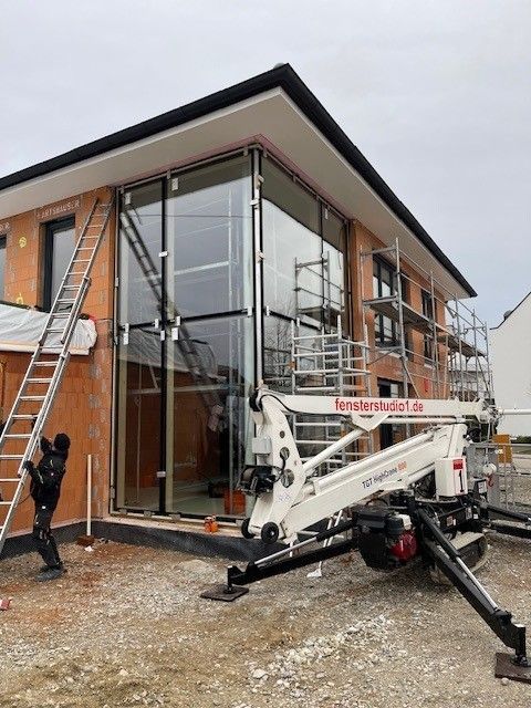 Montage einer großen Fensterfront während der Bauphase eines Wohnhauses