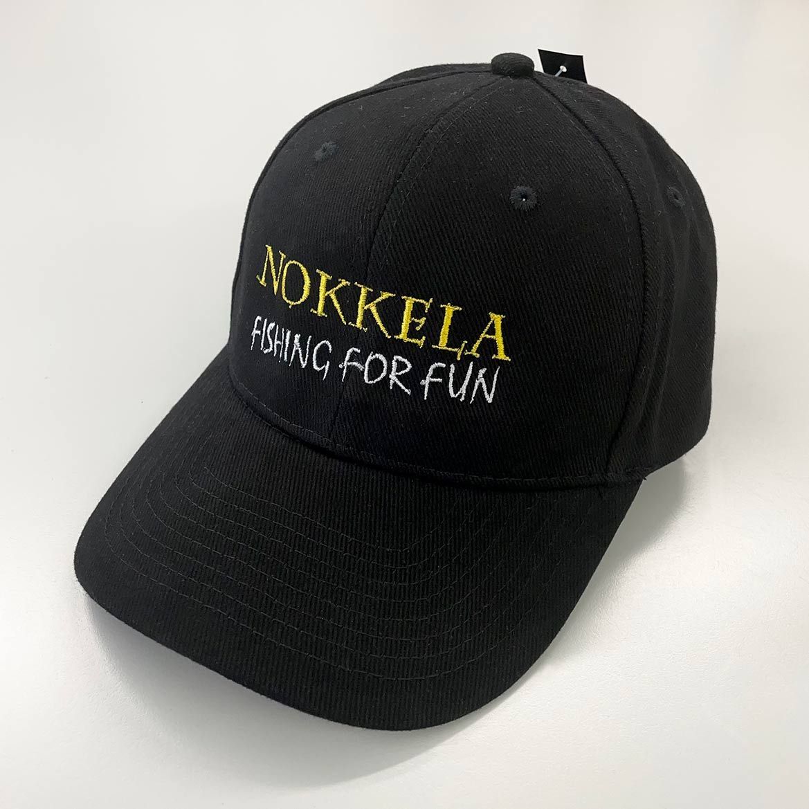 Musta lippalakki, jossa edessä keltainen ja valkoinen teksti ”NOKKELA MOVING FOR FUN”.