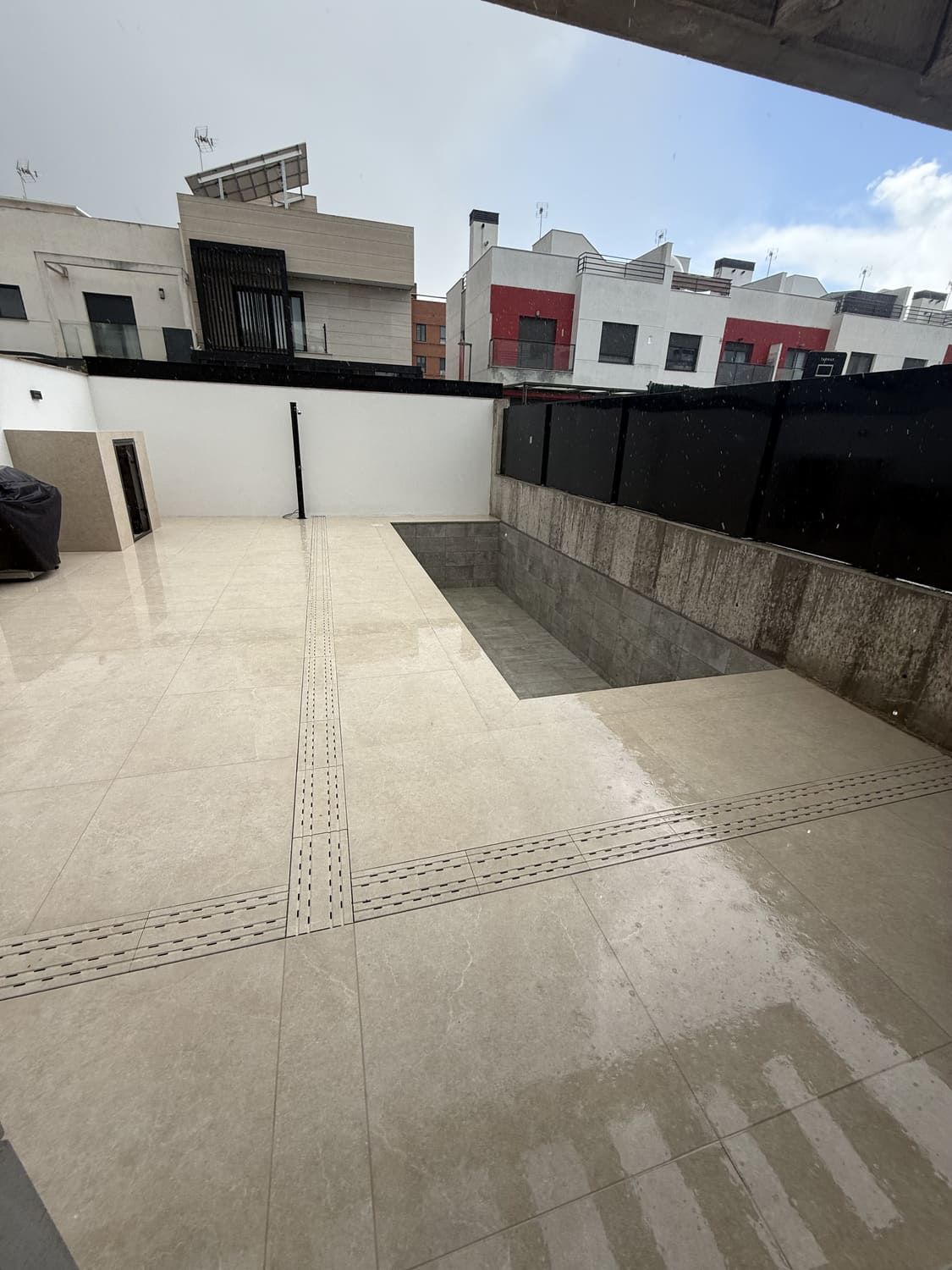 Patio exterior con piscina vacía y edificios circundantes.