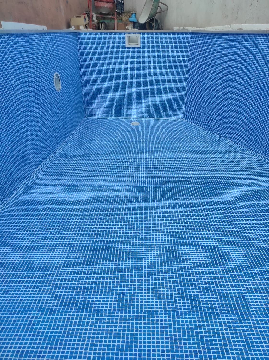 Interior de azulejos azules de una piscina vacía.
