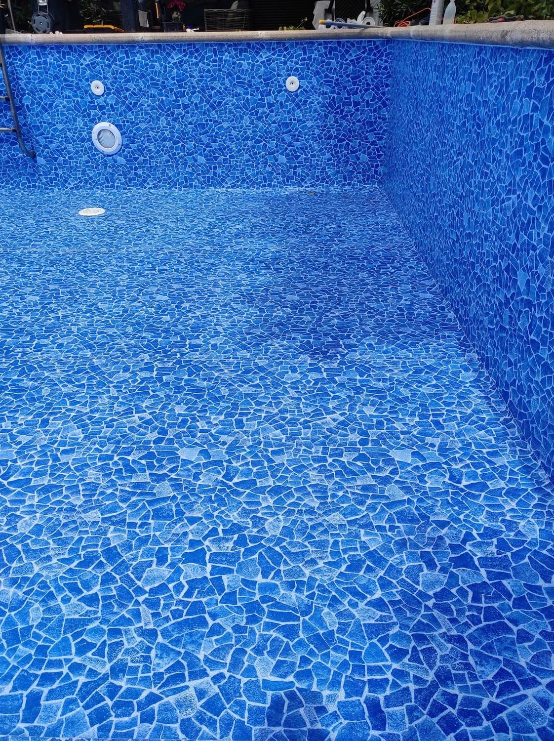 Piscina vacía de azulejos azules, mostrando las paredes y el suelo.