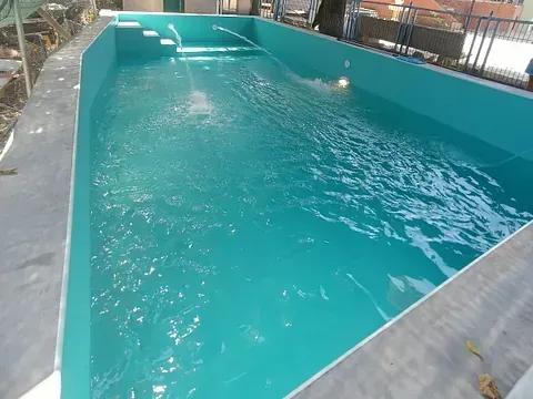 Una gran piscina con agua azul y escaleras.