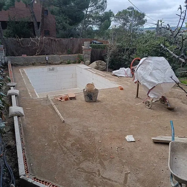 Se está construyendo una gran piscina en un patio trasero.