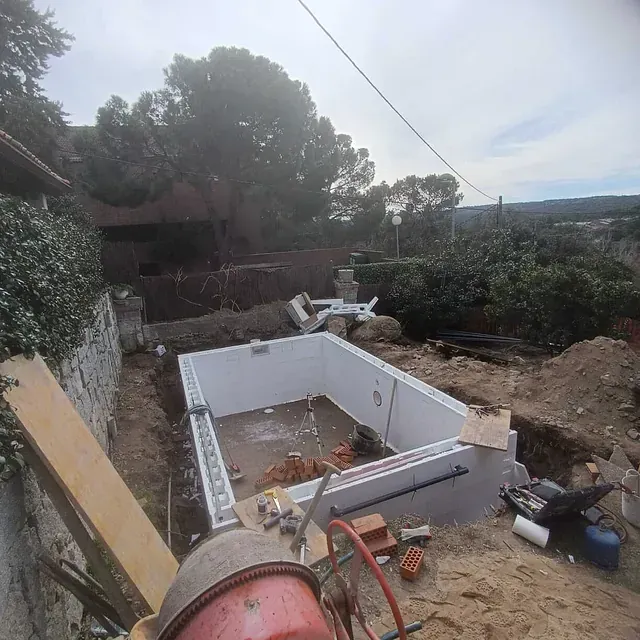 Se está construyendo una gran piscina en un patio trasero.