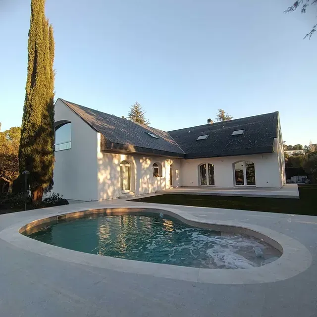 Una casa blanca con una piscina delante de ella