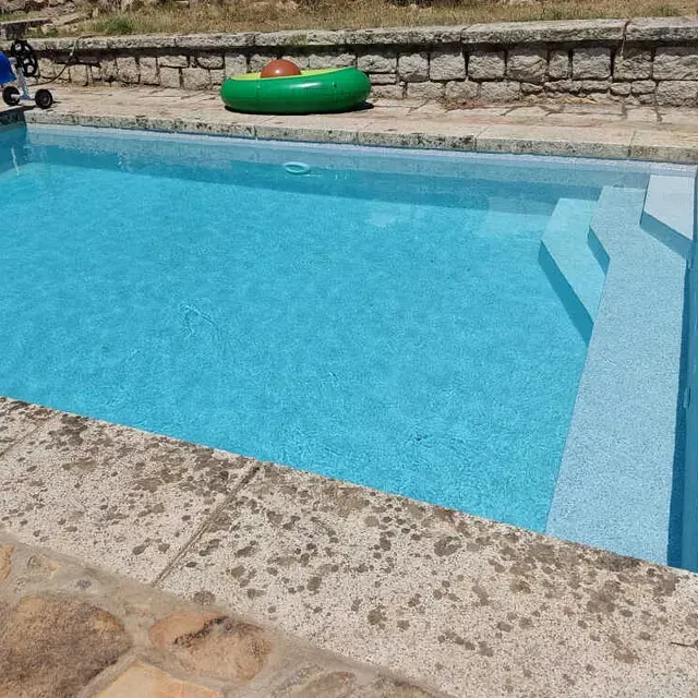 Una piscina con una balsa verde en ella
