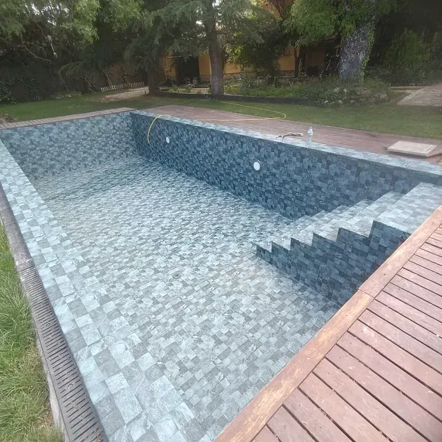 Una gran piscina con escaleras y terraza de madera.