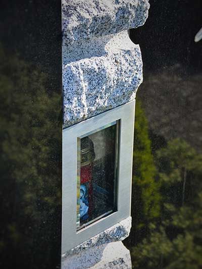 Ein Granitdenkmal mit einem gerahmten Buntglasfenster.