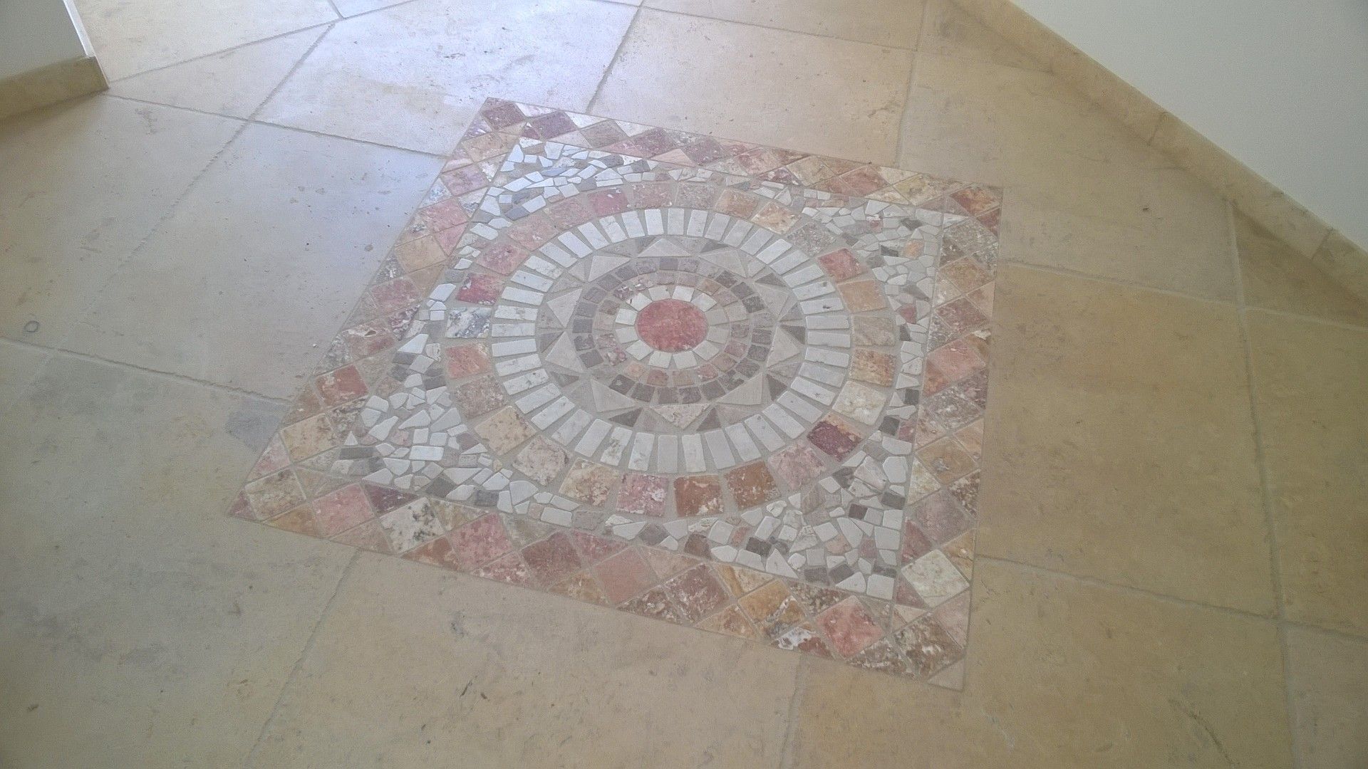 Boden mit quadratischem Mosaikmuster in Beige-, Rosa- und Weißtönen.