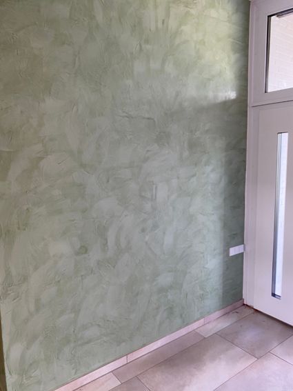 Ein Raum mit einer grünen Wand und einer weißen Tür.