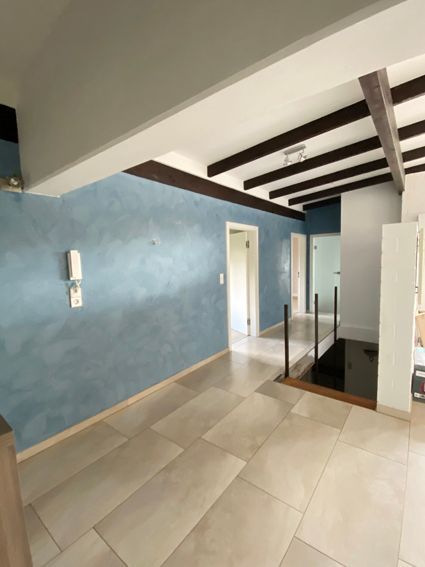 Ein leerer Raum mit einer blauen Wand und einer Treppe