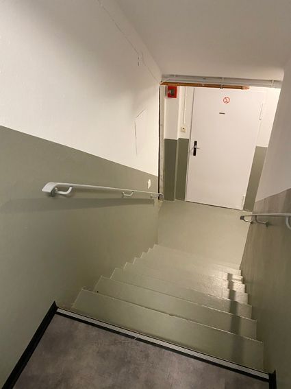 Eine Treppe, die zu einer Tür in einem Gebäude führt.