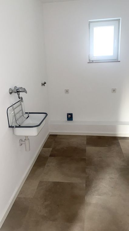 Ein Badezimmer mit Waschbecken und Fenster.