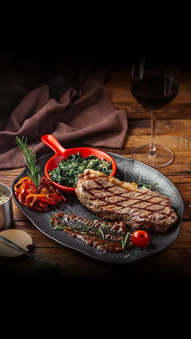Tischset für das Essen im Restaurant; weisse Tischdecke, Teller, Gläser und Besteck.