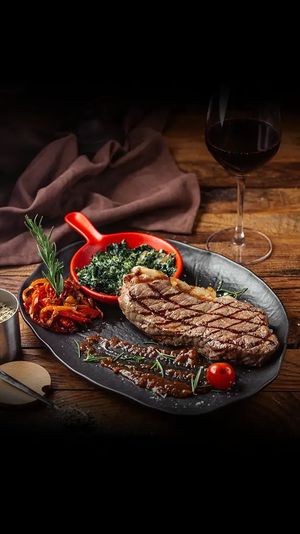 Tischset für das Essen im Restaurant; weisse Tischdecke, Teller, Gläser und Besteck.