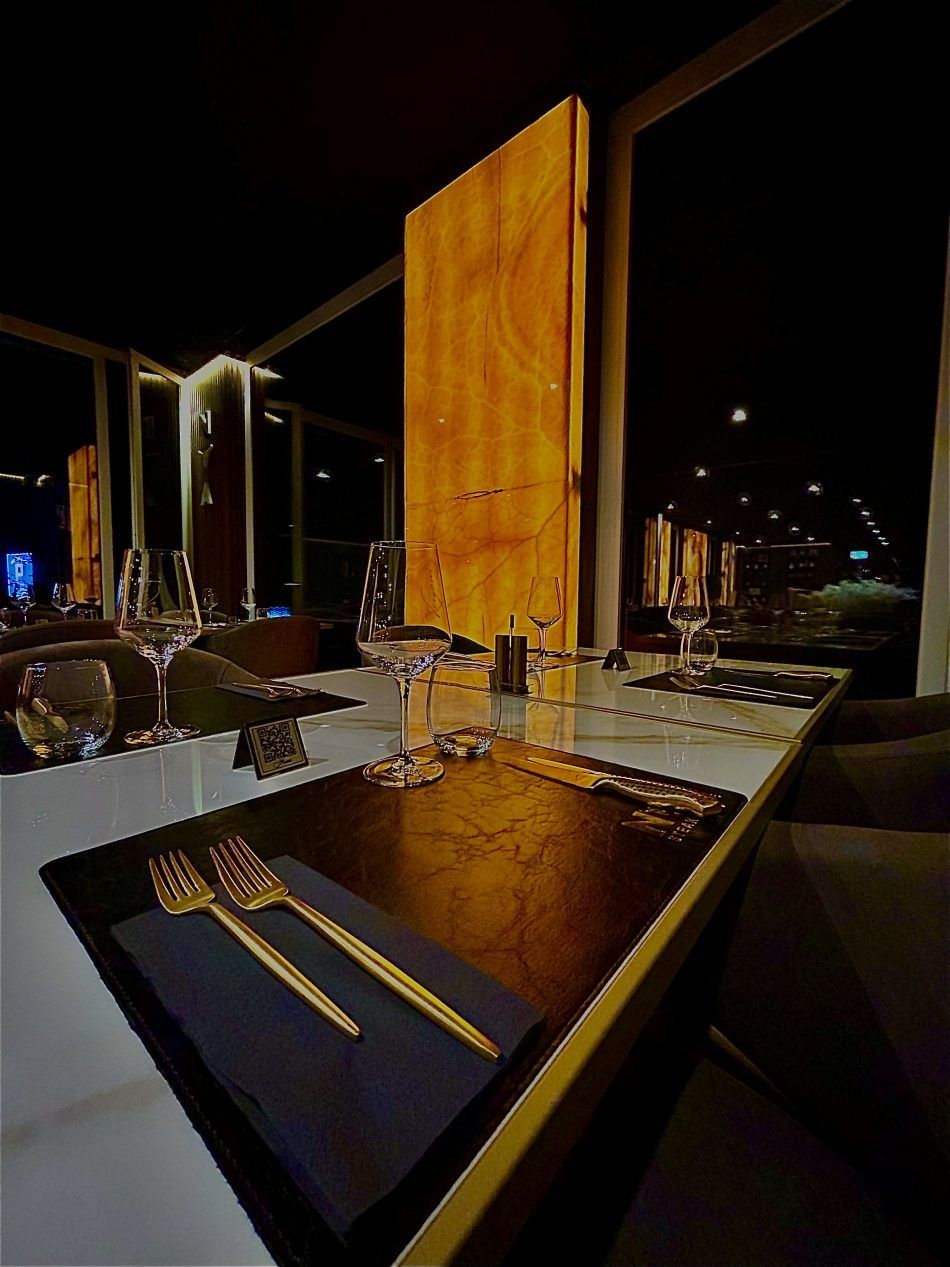 Hähnchenflügel auf einem weissen Schneidebrett mit roter Sosse, garniert mit Petersilie und Sesamsamen.