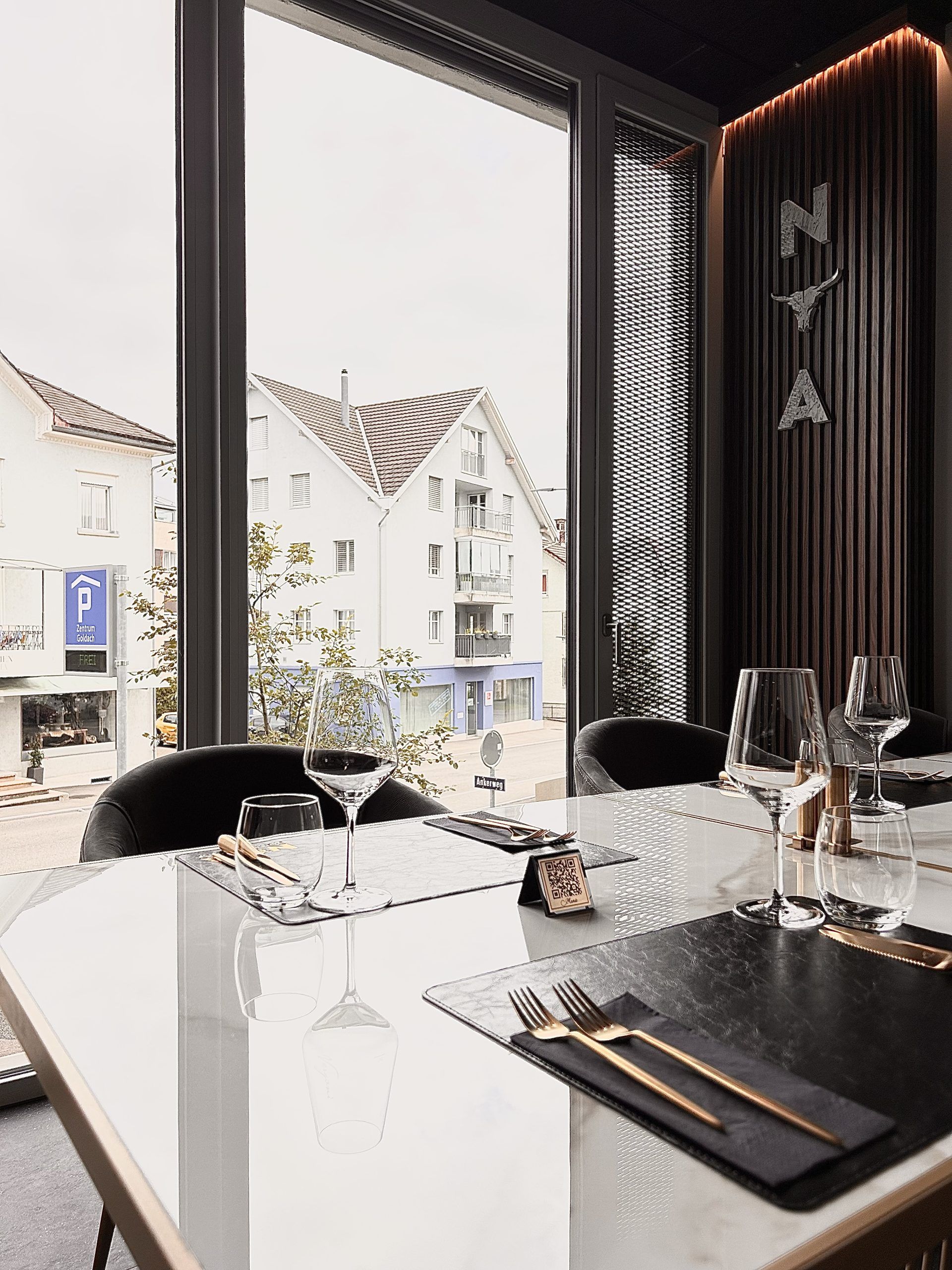 Gegrilltes Steak auf einer Schieferplatte, in Scheiben geschnitten und mit Rosmarin garniert auf einem dunklen Holztisch.