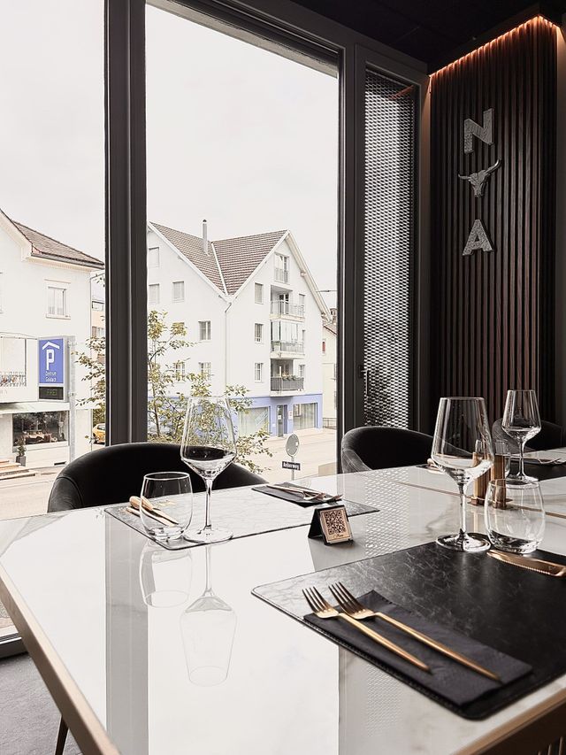 Gegrilltes Steak auf einer Schieferplatte, in Scheiben geschnitten und mit Rosmarin garniert auf einem dunklen Holztisch.