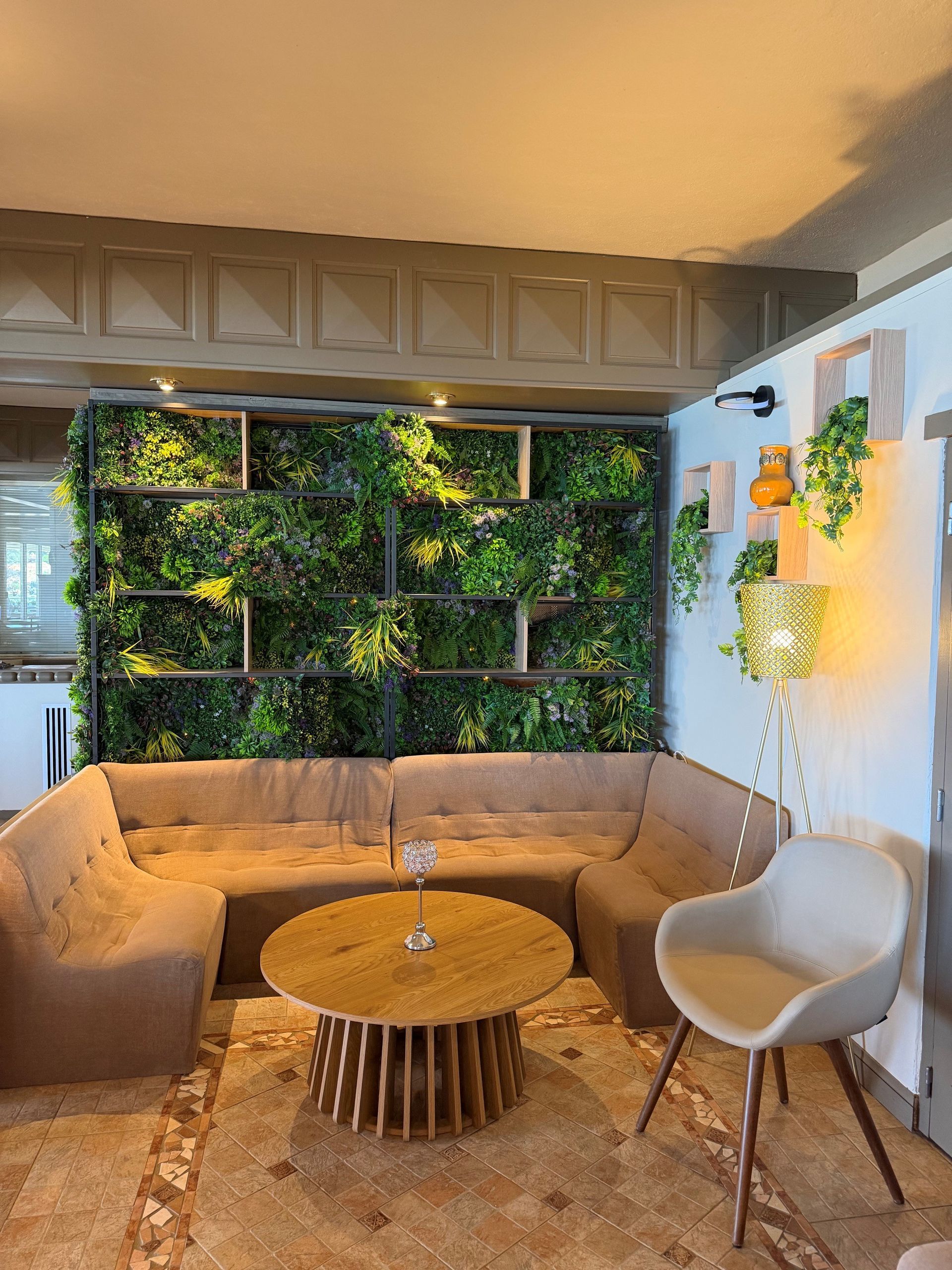 Un salon dans le restaurant avec un canapé beige et des fauteuils.