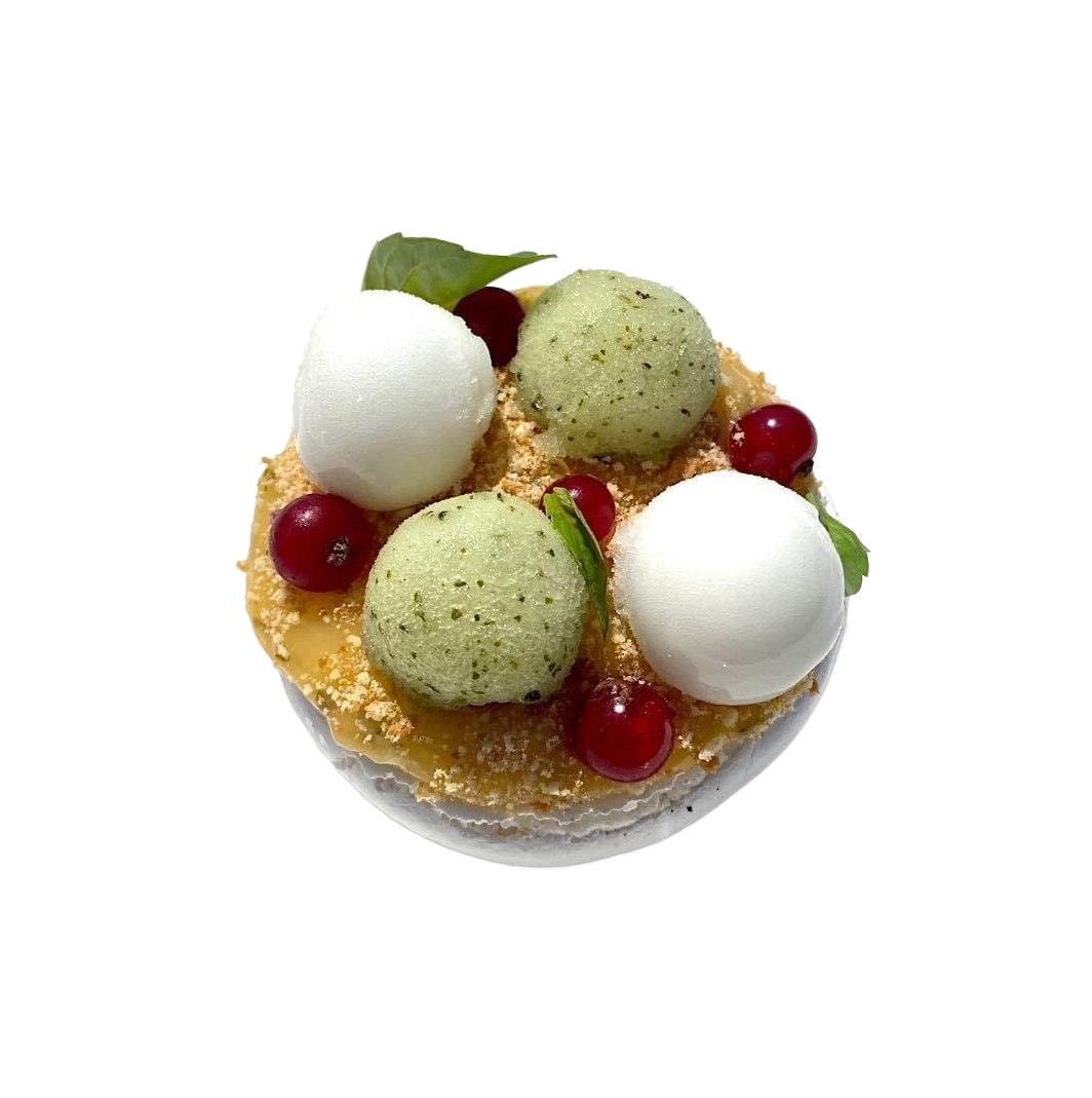 Dessert rond garni de boules de glace blanches et vertes, de fruits rouges et d'une croûte dorée à mijoter.
