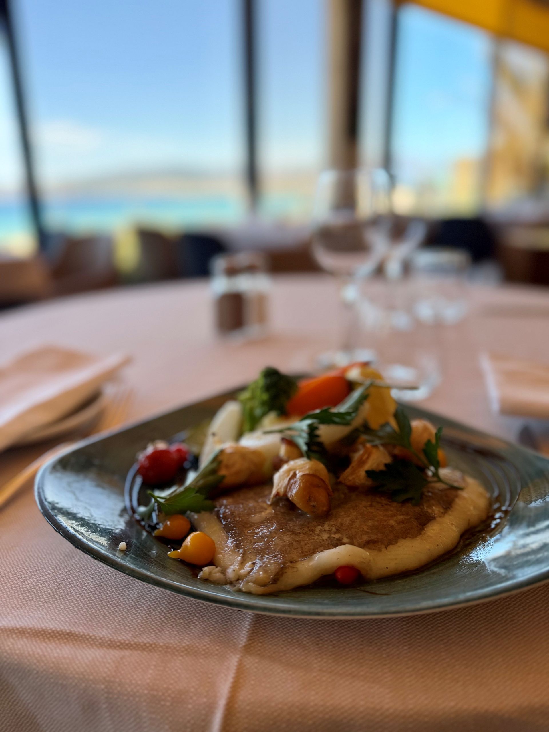 Un plat à base de légumes sur une table avec vue sur la mer.