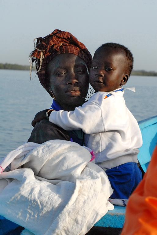 chantal gayaud femme Sénégalaise de couleur noire  et son enfant traversant la rivière sur une embarcation