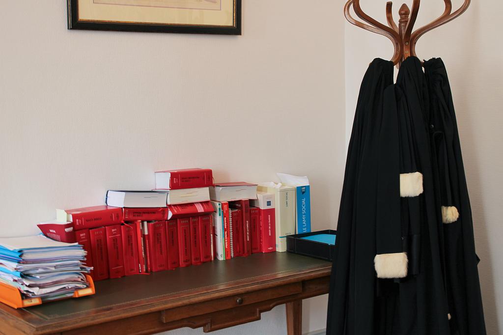 Livres de droit et robes d'avocat accrochées à un porte-manteau