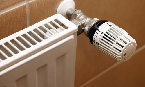 Un primer plano de un radiador con un termostato.