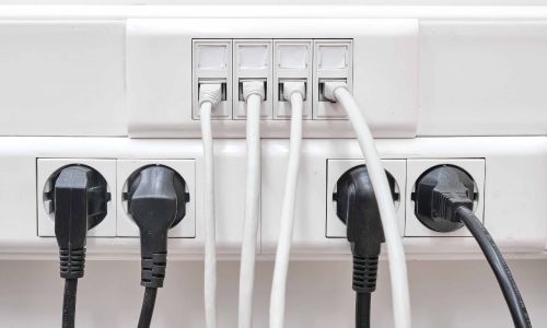 Un montón de cables están conectados a una toma de corriente.
