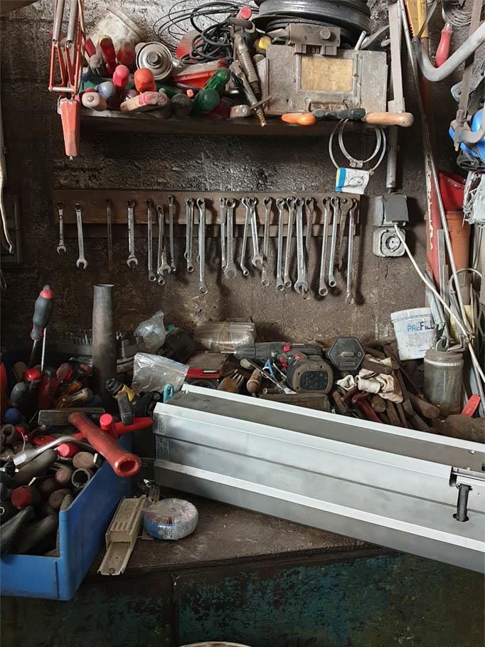 Ein Haufen Werkzeuge hängen an einer Wand in einer Garage