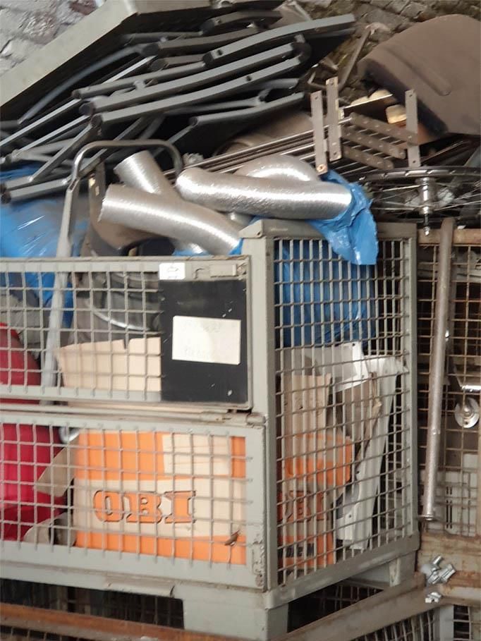 Ein Metallkäfig mit verschiedenen Gegenständen, darunter eine Schachtel mit der Aufschrift „TNT“