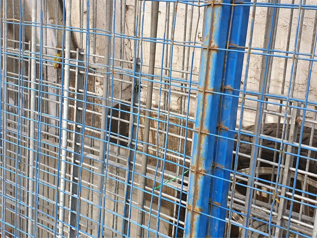 Eine Nahaufnahme eines blau-weißen Maschendrahtzauns.