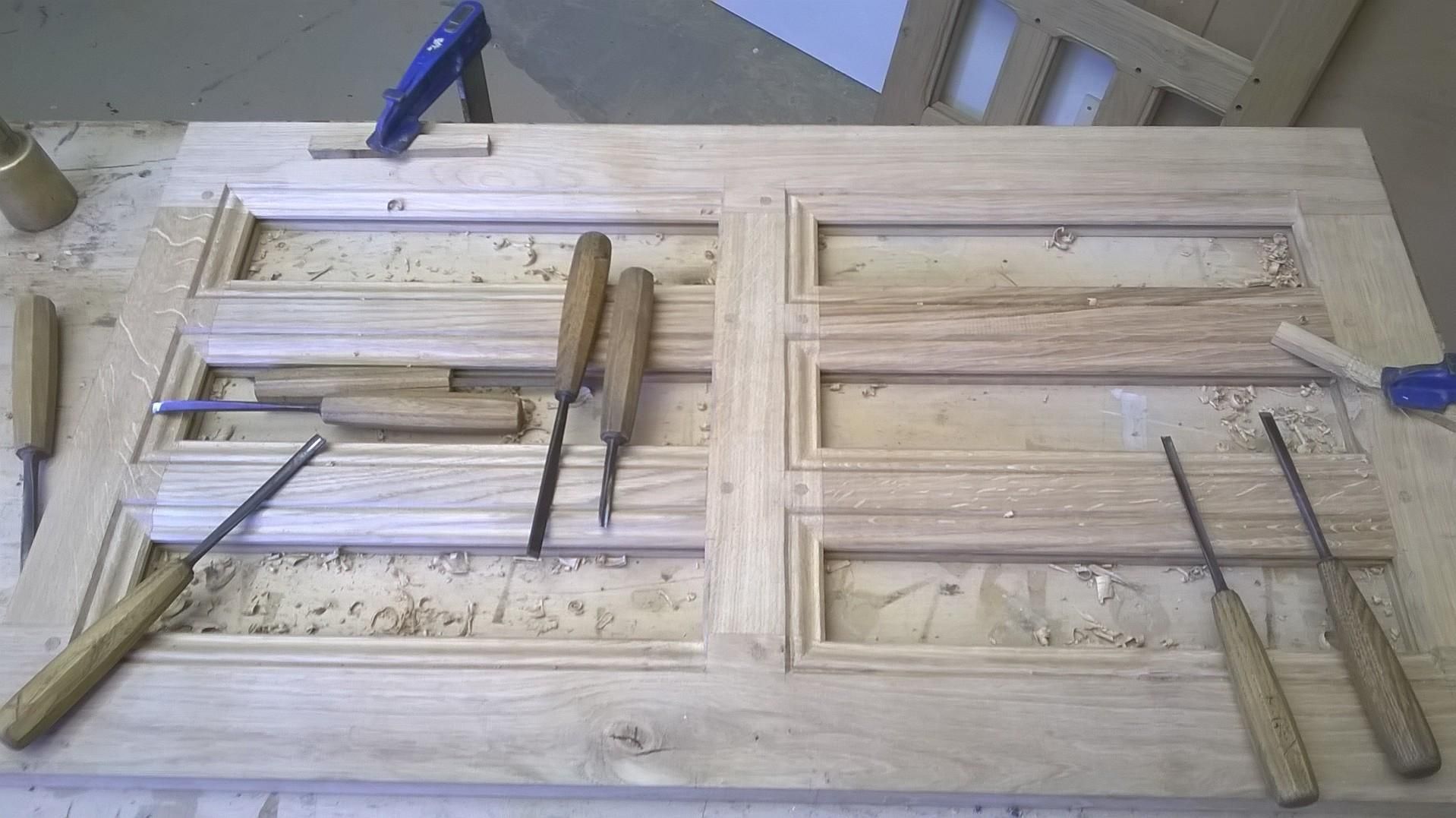 Porte en bois sculptée avec des motifs de ciseaux, établi.