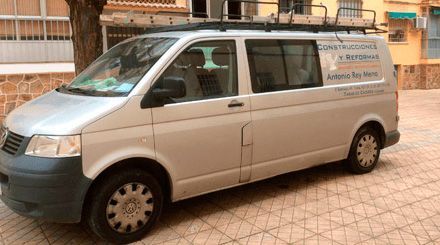 Una camioneta blanca está estacionada frente a un edificio.