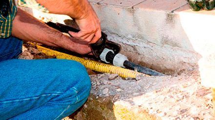 Un hombre está trabajando en una tubería con un martillo.