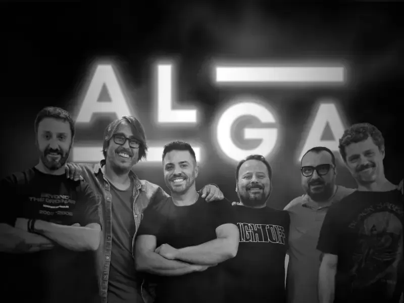 Seis hombres sonrientes posando frente a un letrero luminoso de ALGA.