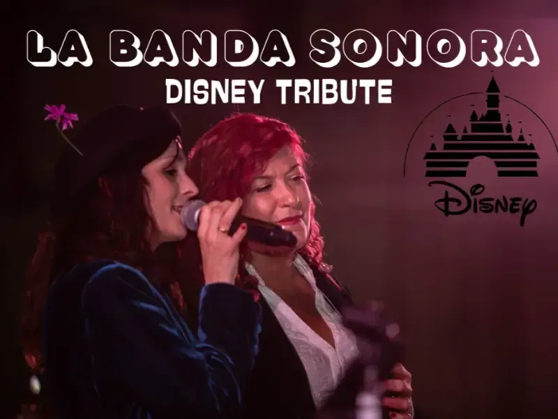 Dos cantantes en el escenario con el texto “La Banda Sonora Disney Tribute” y el logotipo de Disney de fondo.