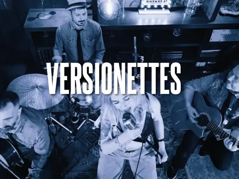 Vista aérea de una banda con tonos azules actuando en directo con el texto “VERSIONETTES” centrado.