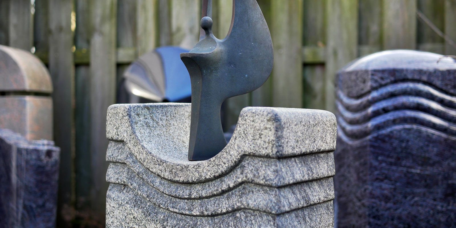 Eine Vogelstatue ist von anderen Skulpturen umgeben