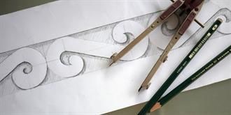 Ein Zirkel und Bleistifte liegen auf einem Blatt Papier.