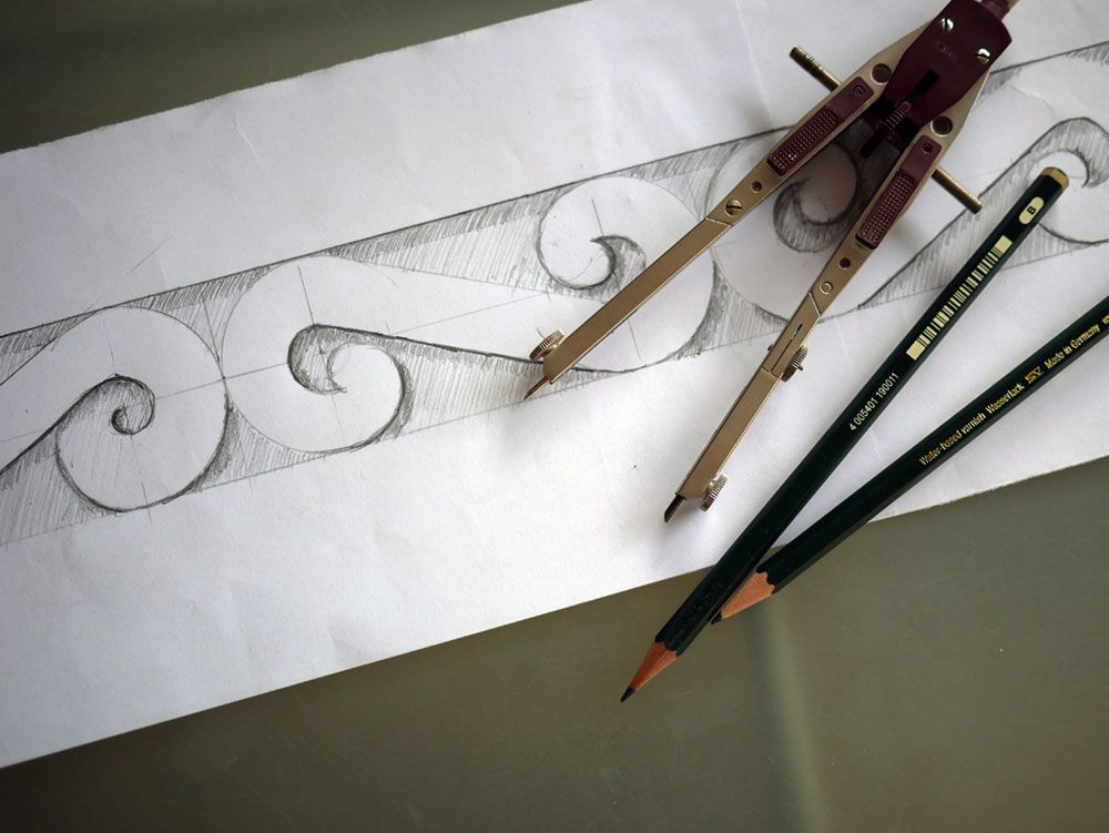 Zwei Bleistifte und ein Zirkel auf einem Blatt Papier