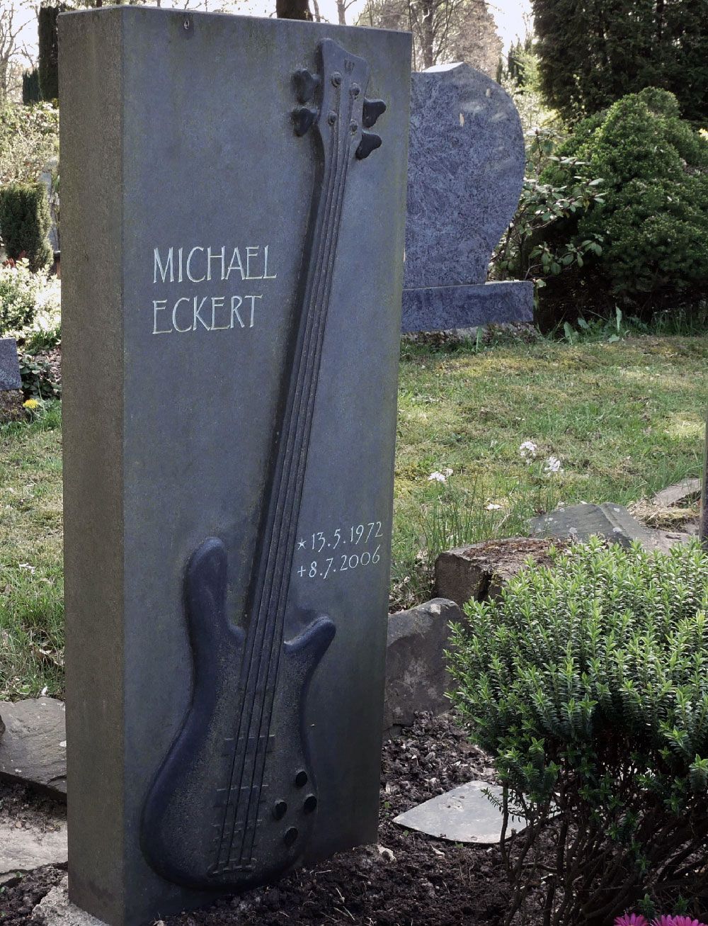 Ein Grabstein für Michael Pokeri mit einer Gitarre darauf