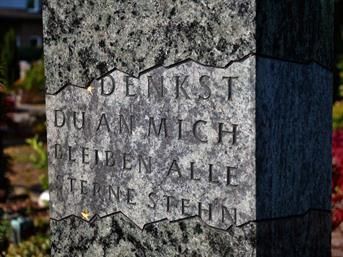 Eine Nahaufnahme einer Steinsäule mit einem eingemeißelten Zitat.