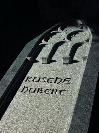 Eine Nahaufnahme eines Grabsteins mit dem Namen Hubert darauf.
