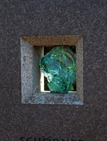 Ein quadratisches Loch in einer Steinmauer mit einem grünen Objekt darin