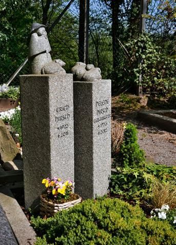 Ein Friedhof mit der Statue eines Mannes und eines Hundes auf einer Steinsäule.