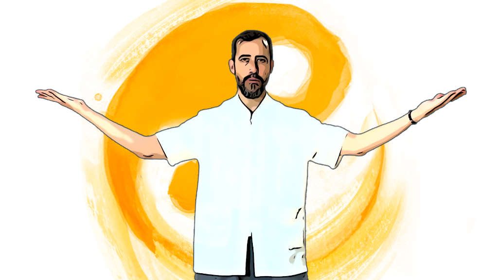 Un hombre con barba está de pie con los brazos extendidos.