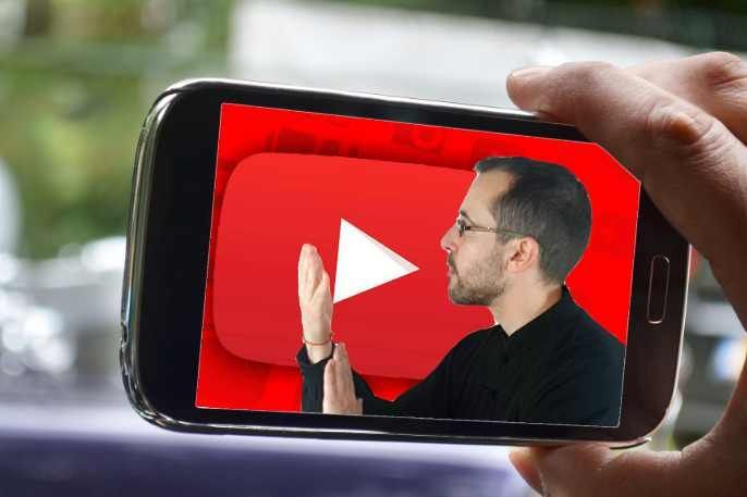 Una persona sostiene un teléfono celular con un logotipo de YouTube en la pantalla.