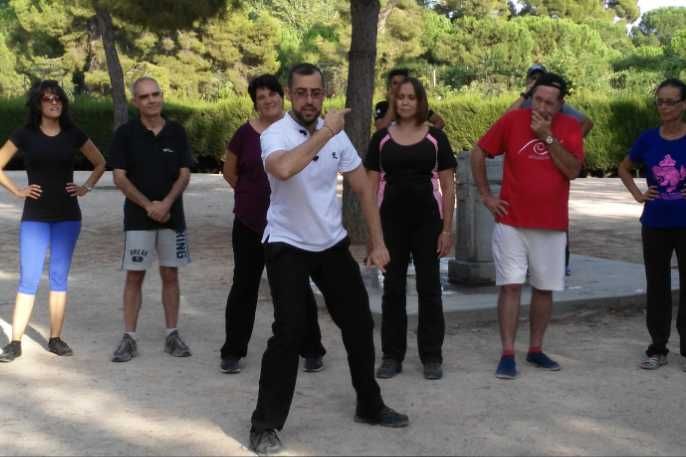 Un hombre con una camisa blanca está parado frente a un grupo de personas.